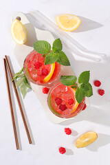 Lemonade cocktail,mojito with tequila, gin, rum, vodka, liqueur, lime, ice and fresh raspberries, bar and party concept, restaurant and cafe advertising card, black background, selective focus.