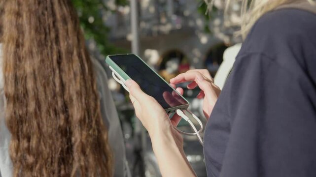 Young female traveler looking at gps map on mobile phones while driving around city traveler using smartphone to check map to travel with internet and gps app, power bank charges the phone
