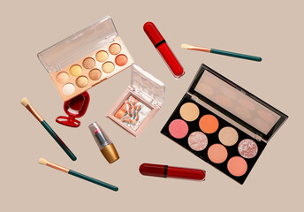 Flying decorative cosmetics on beige background