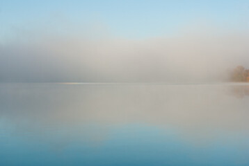 Blue natural background, fog at dawn over the lake.