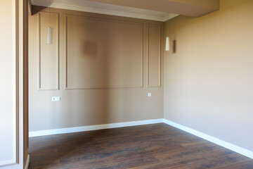 A room with a white wall and wooden floor