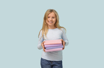 Cute little girl with books on blue background
