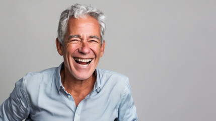 Handsome man 50s mid age beautiful physically fit well groomed senior model grey hair and beard laughing Healthy face skin care skincare hair care fitness dental off center copy space gray background