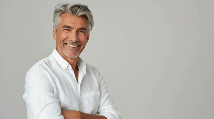 Handsome man 50s mid age beautiful physically fit well groomed senior model grey hair and beard smiling Healthy face skin care skincare hair care fitness dental off center copy space gray background