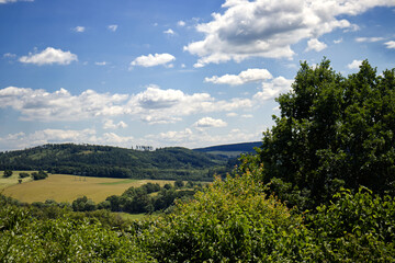 Obraz premium Beautiful landscape on a sunny day. Landscape with mountains, meadows and trees. Blue sky with white clouds. Summer, season, landscape, sunny day.