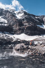 Hiker having a break at an alpine glacier lake