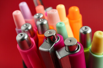 Many pens on red background, closeup