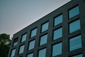black tall minimalist street view building with large full length windows