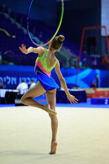 A rhythmic gymnast displays artistry, precision, and strength with a hoop in competition