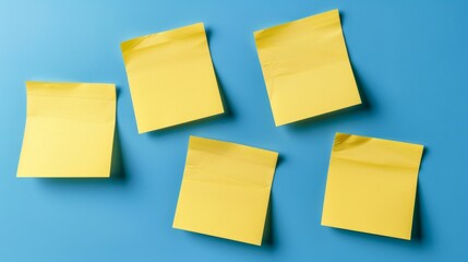Five yellow sticky notes arranged on a bright blue surface, creating a vibrant and organized appearance.