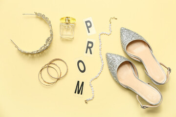Word PROM with female shoes, tiara and perfume bottle on light yellow background