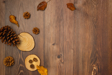 Cones and leaves on wooden background. Autumn composition. Copy space, top view