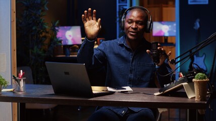 Man arriving in studio, greeting audience, broadcasting live using professional tools producing...