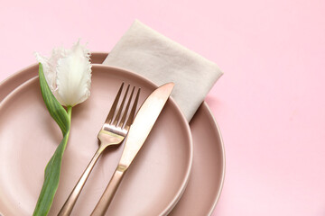 Stylish table setting with beautiful tulip on pink background