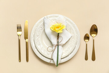 Stylish table setting with beautiful flower on beige background