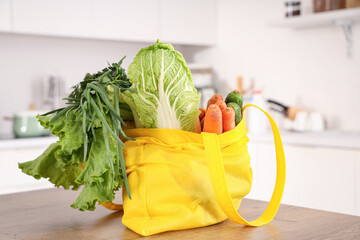 Yellow shopper bag full of fruits and vegetables in kitchen