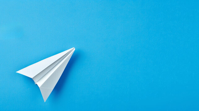 A vivid blue background with a stylized white paper airplane, symbolizing the simplicity and joy of travel