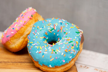 Delicious dessert. Pink, blue and chocolate donuts with multicolored sprinkles.