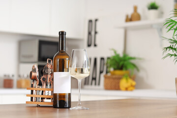 Bottle and glass of wine on wooden table in kitchen
