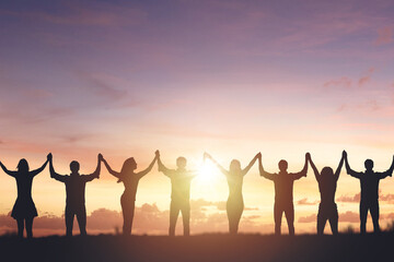 Silhouette of people holding hands against sunset background, concept of peace and victory