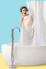 Shocked young woman with hair curlers behind curtain in bathtub on blue background