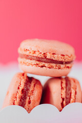Macaroons .Sweet pink pastries. Macaron cakes set.white cardboard box filled with pink macarons set against a pink backdrop.French pastries set..Assorted sweet pastries. 