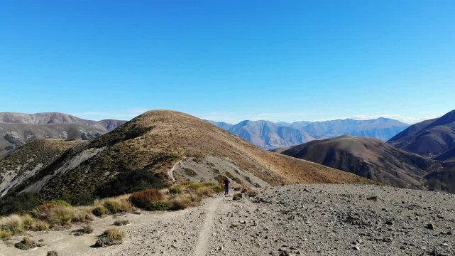 Aerial drone view of a trail winding through dramatic mountains and turquoise alpine lakes on the way to Trig M in the Torlesse Tussocklands near Springfield, Canterbury, South Island, New Zealand