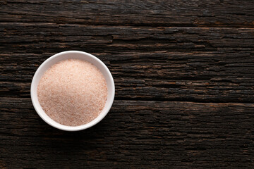 Himalayan pink salt in wooden bowl - Green background