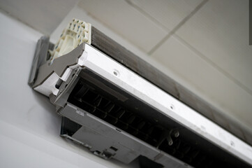 Air conditioning service. Technician fixing air conditioner indoors. Repair and maintenance concept.