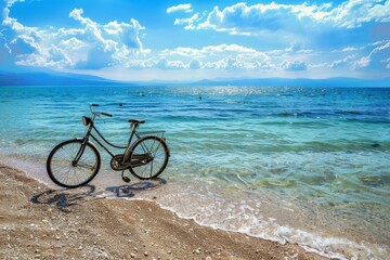 Fototapeta premium Vintage bicycle is parked on a secluded beach, with crystal clear turquoise water gently lapping at the shore