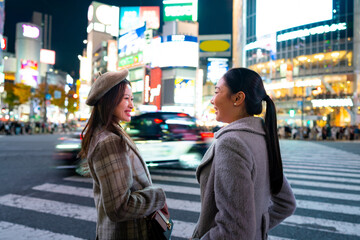 Asian woman shopping and walking city street crosswalk with crowd of people in Shibuya, Tokyo,...