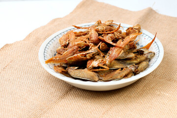 Ikan asin goreng or fried salted fish is one of traditional Indonesian food, isolated on white background, dried salted fish, good for article