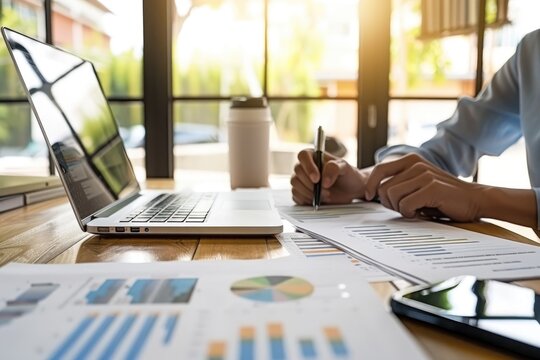 A tax advisor sitting at a desk with a laptop and financial documents, explaining tax planning strategies to a client in an office