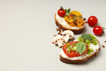 Sandwiches with grilled vegetables on a board, on a light background.