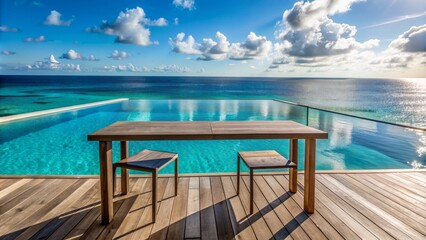 Fototapeta premium Sleek, weathered wooden table stands alone on a tranquil beachside patio, overlooking a stunning infinity pool and turquoise ocean horizon.
