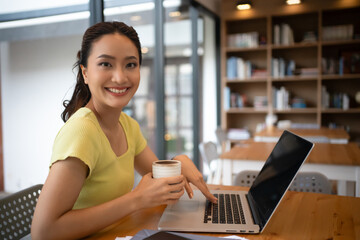 Fototapeta premium Woman sitting working with laptop at coffee shop, freelance woman working outside Concept.