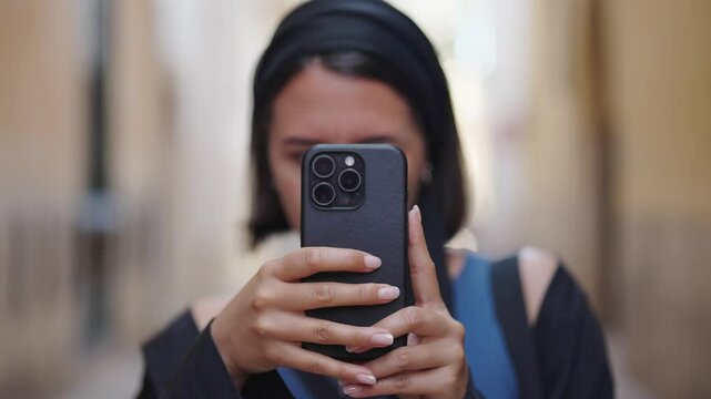 Caucasian female tourist in Mallorca hold smartphone and take photos