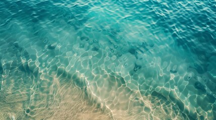 Fototapeta premium Clear turquoise sea water with sunlight reflecting off of the gentle waves, creating a calm and serene underwater scene with a sandy seafloor.