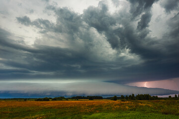 Supercell cloud with distant lightning illuminating the storm structure