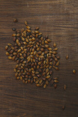 roasted barley grain on a wooden table. food background
