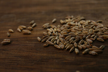 Obraz premium roasted rye grains on a wooden table, food background