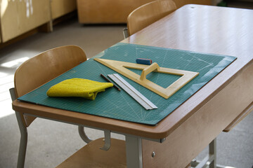 Classroom desk with math tools, ruler, and eraser on a cutting mat