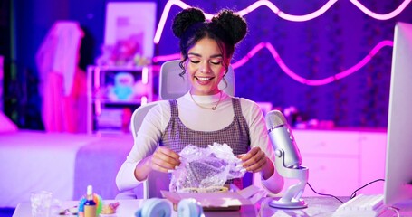 Unboxing, live stream and influencer woman with microphone, makeup and neon light in home studio....