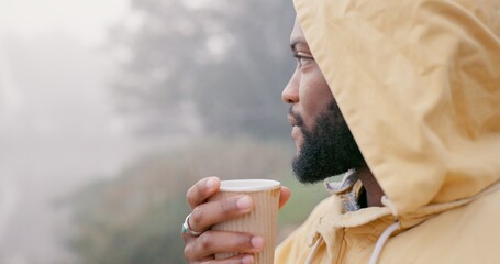 Coffee, thinking and black man drinking in storm for hiking, travel and relax in morning outdoor in winter. Tea, peace and mindfulness in nature for adventure, camping or rain with raincoat as break