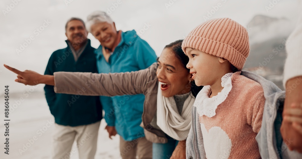 Wall mural Family, child and beach with pointing, happy and grandparent together on vacation by sea with view. Love, smile and young girl with mother outdoor in winter on holiday with retirement and travel