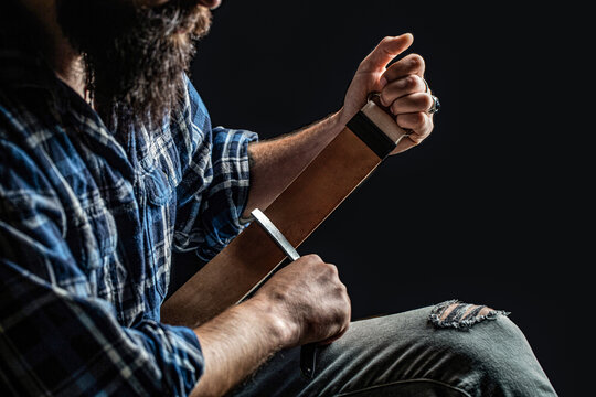 Straight razors, barbershop, beard, blade. Straight razor. Vintage tools for barbers, razor, sharpen the blade in leather brush, razor blades. Man stropping straight razor with leather tool