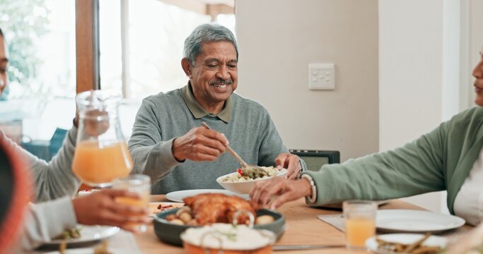 Senior man, family and lunch with smile, sharing and helping hand for food, care and connection in home. People, eating and happy with meal on table for reunion, holiday or celebration in dining room - Powered by Adobe