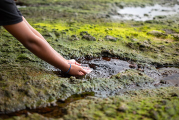 A girl is washing her hands in a natural spring pool