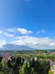  Portrait view of clouds between mountains taken from the top of a hill and showing views of the city