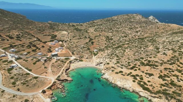 Beautiful beach on Donousa Island in Greece, with turquoise Aegean Sea waters and a small village in the hills